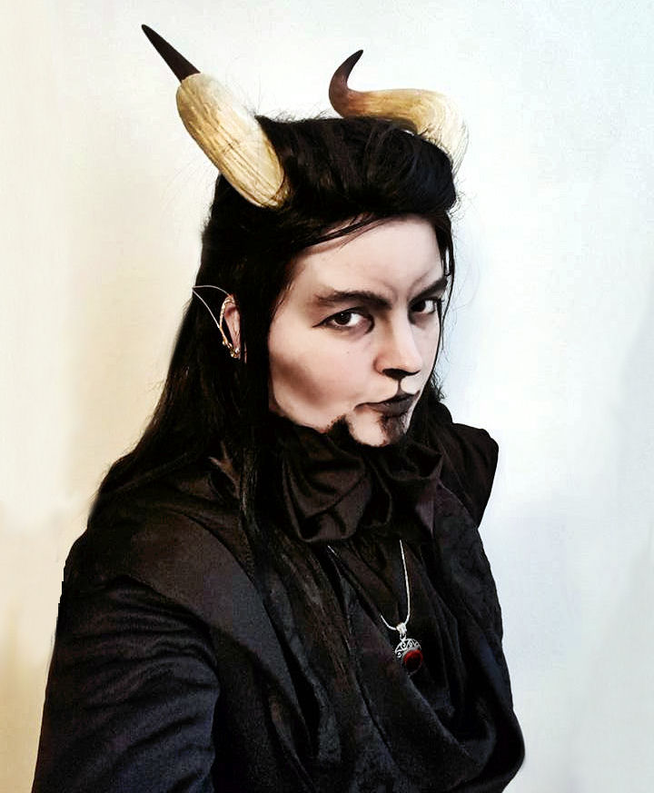 A photo of Valtinen dressed in black wearing horns on his head with dark face makeup.