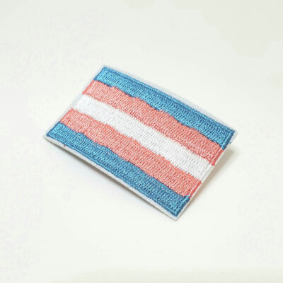 A fabric patch of a blue, white, and pink transgender flag.